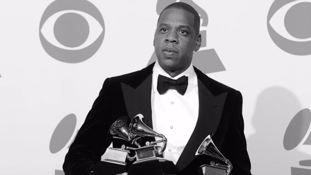 JAY-Z poses while holding GRAMMY awards