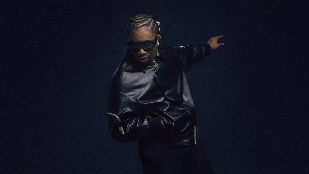 Oxlade wears a black leather jacket against a dark backdrop