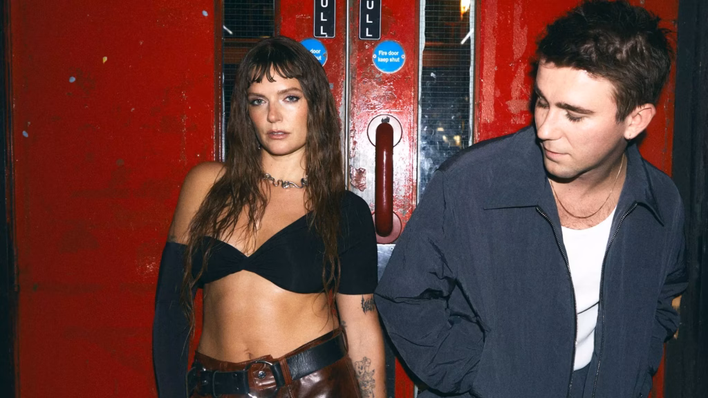Tove Lo (L) and SG Lewis (R) pose in front of a set of red doors