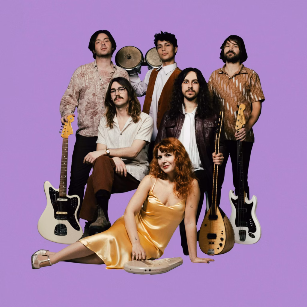 the band Altin Gün poses in front of a purple background