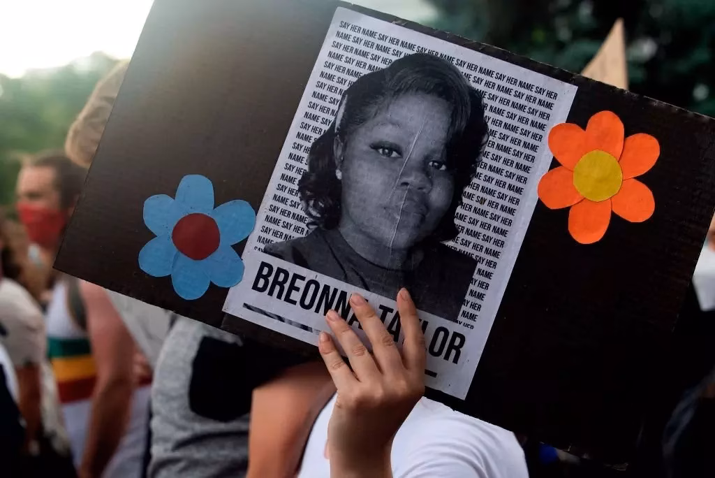 A demonstrator holds a sign with the image of Breonna Taylor