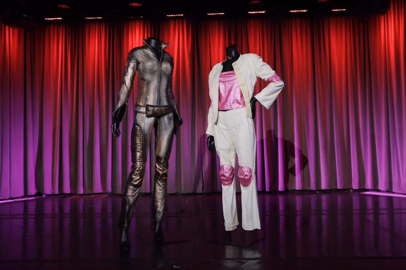 Britney Spears' original tour outfits: a pink-and-white vinyl look from her 1999 debut headlining tour (R) and a crystal-studded jumpsuit from her 2001-2002 Dream Within a Dream tour. 