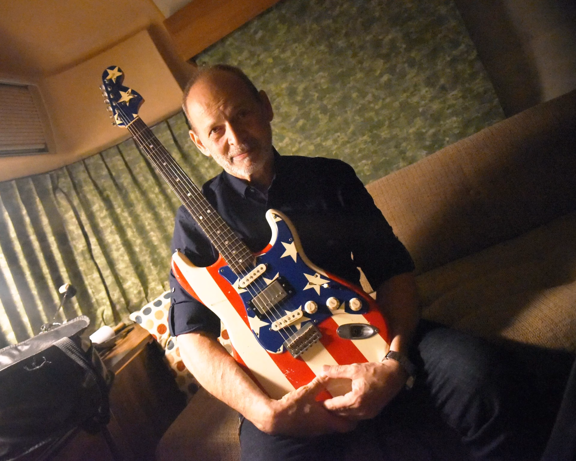 Wayne Kramer of MC5 holding American flag Stratocaster