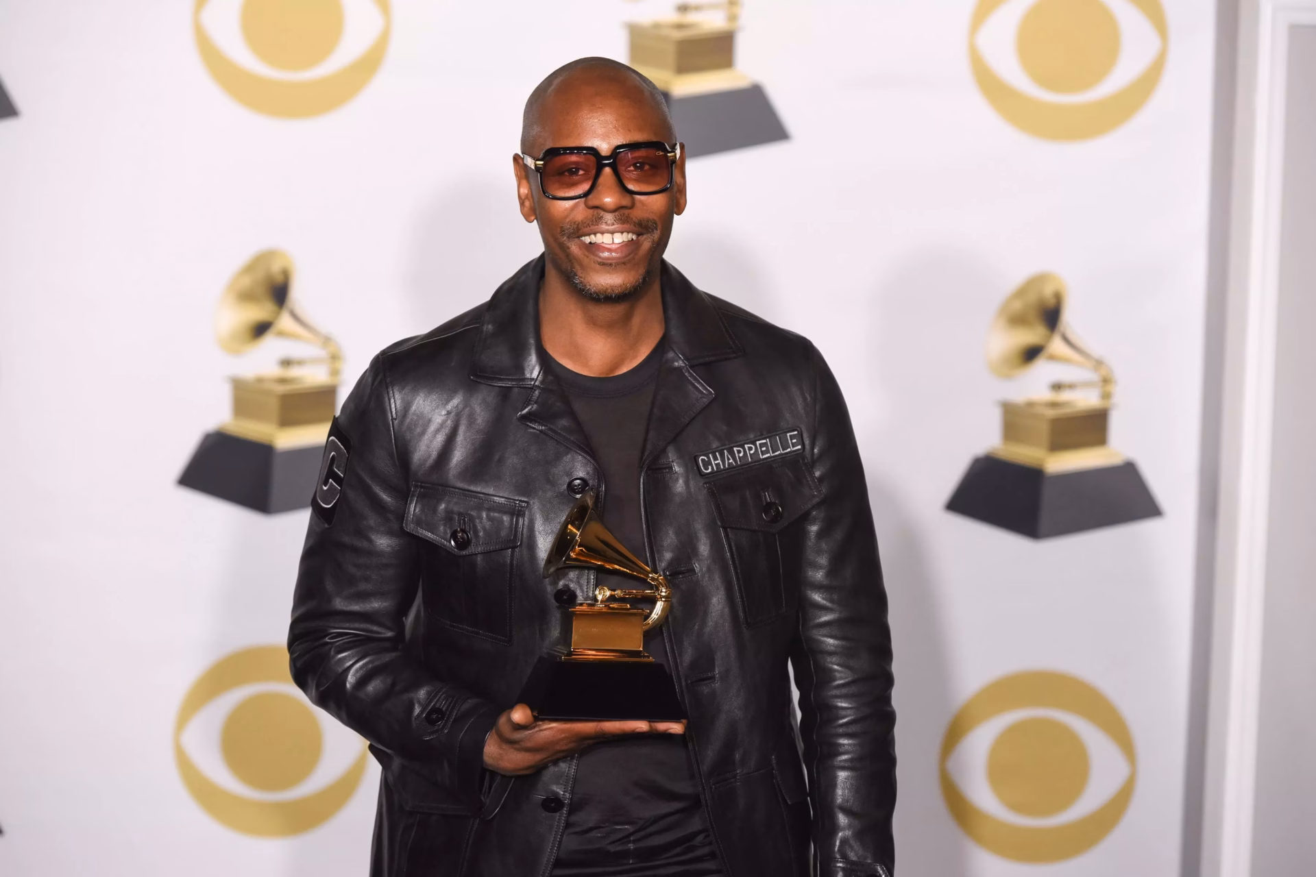 Dave Chappelle holding a GRAMMY