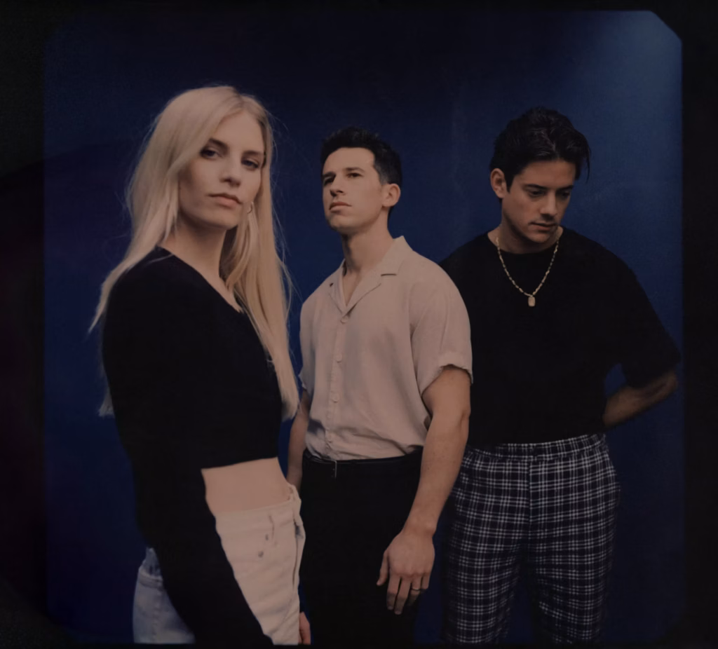 U.K. trio London Grammar pose in front of a dark background