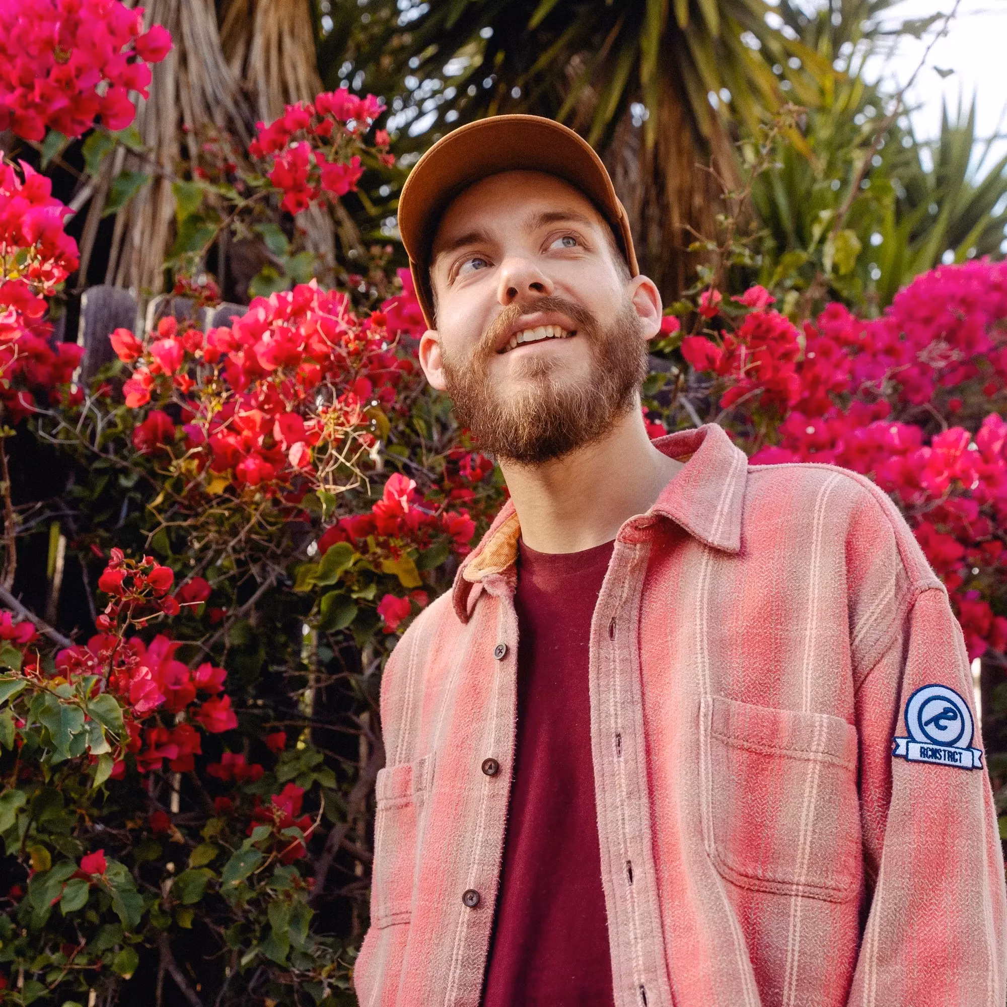 San Holo smiles in front of flowers