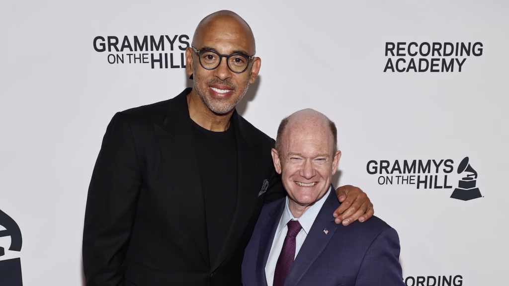 (L-R) Grammys CEO Harvey Mason jr. and U.S. Sen. Chris Coons (D-Del.) attend the 2026 GRAMMYS On The Hill Awards in Washington, D.C. Mason jr. and Coons are standing in front of a GRAMMYS On The Hill step and repeat backdrop and smiling at the camera.